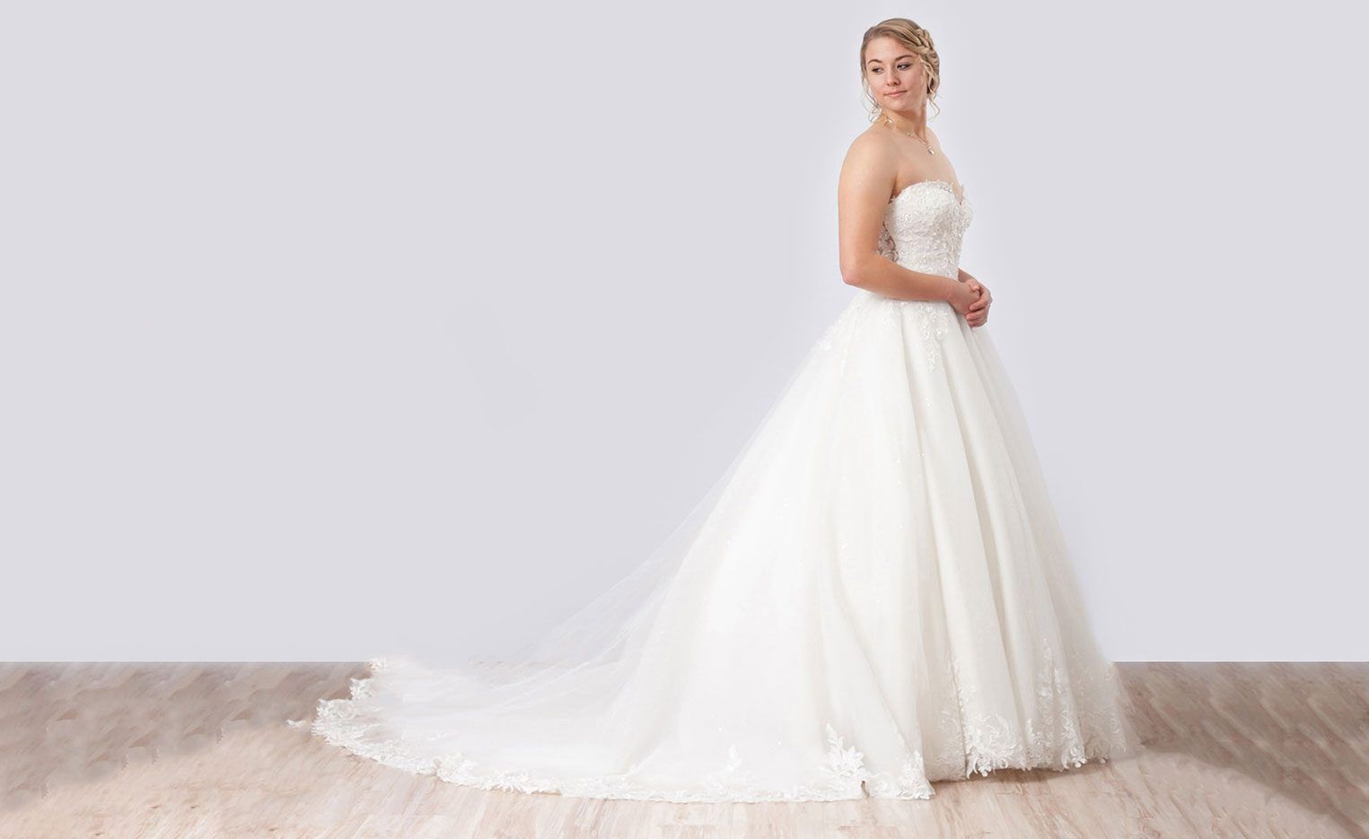 Braut in einem weißen Prinzessinnen-Brautkleid mit Tüllrock und Schleppe im Atelier